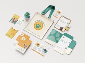 A branding suite for "Paws for Companions," featuring tote bags, mugs, flyers, and stationery. 
