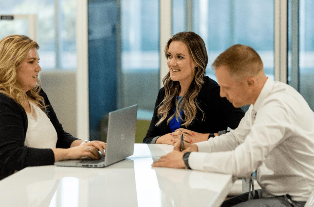 A group of professionals sits in an office while discussing digital marketing.