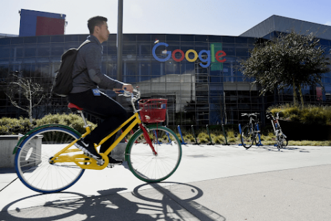Man rides on bike outside of Google HQ